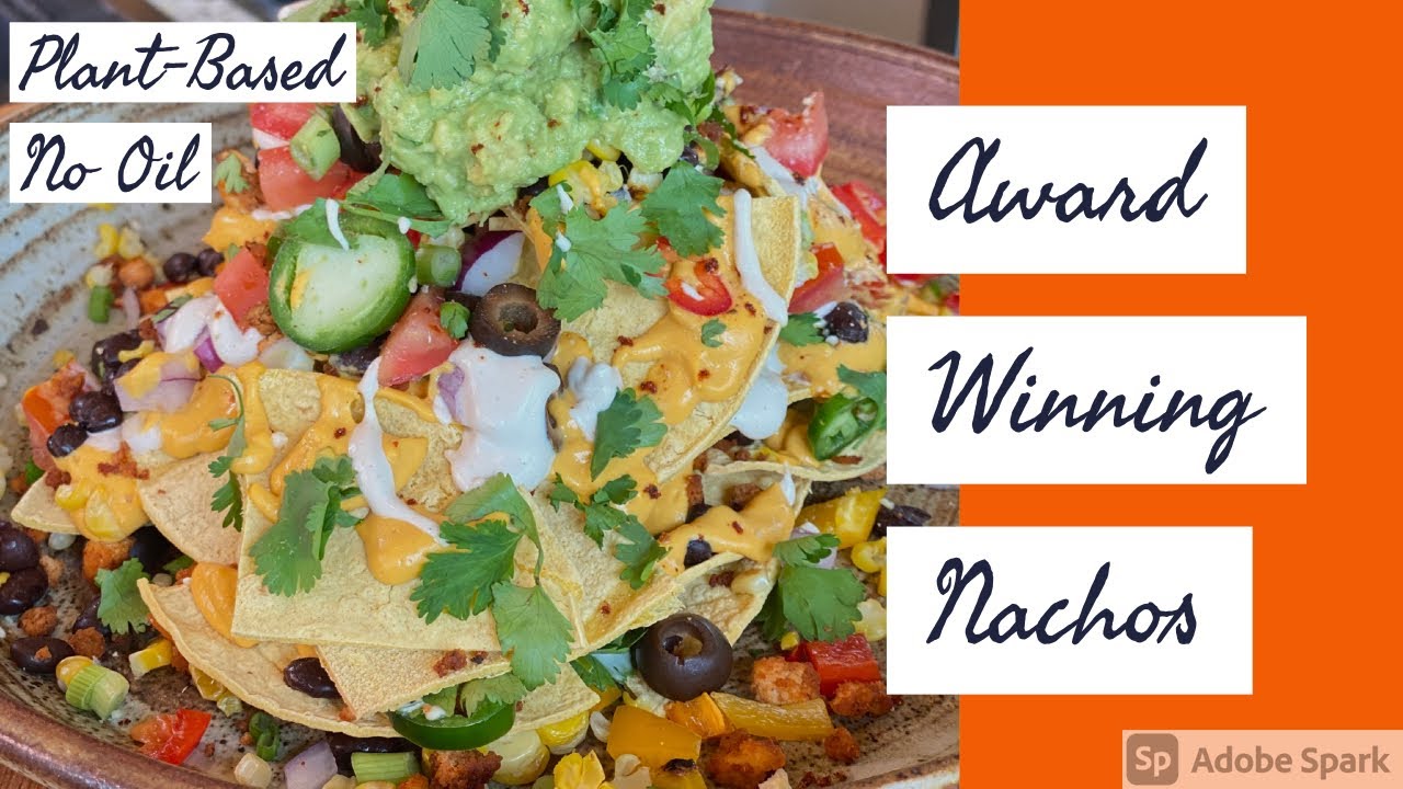 A large plate of oil-free plant-based nachos with cashew cheese sauce and guacamole